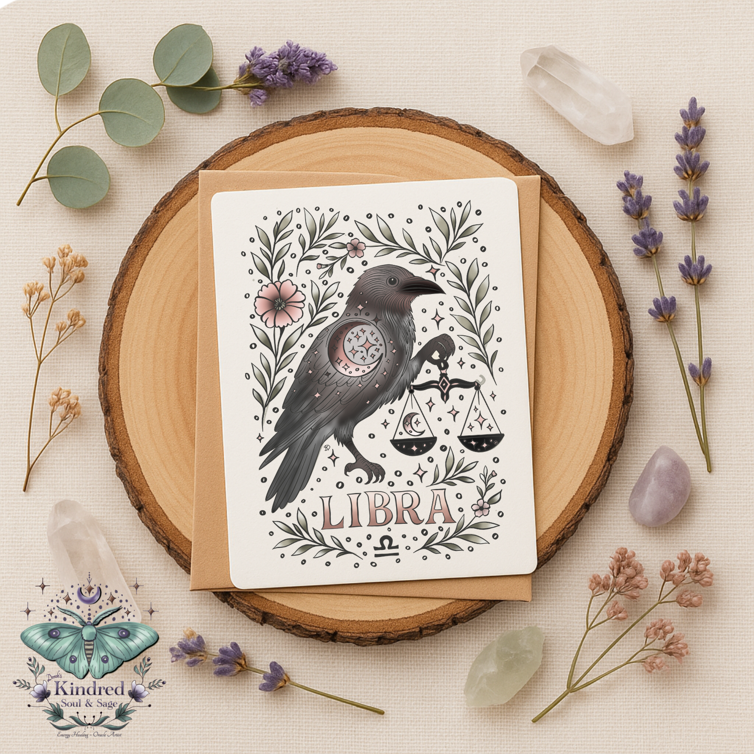 Greeting card with a bird illustration and 'Libra' text on a wooden round surface with flowers and crystals.
